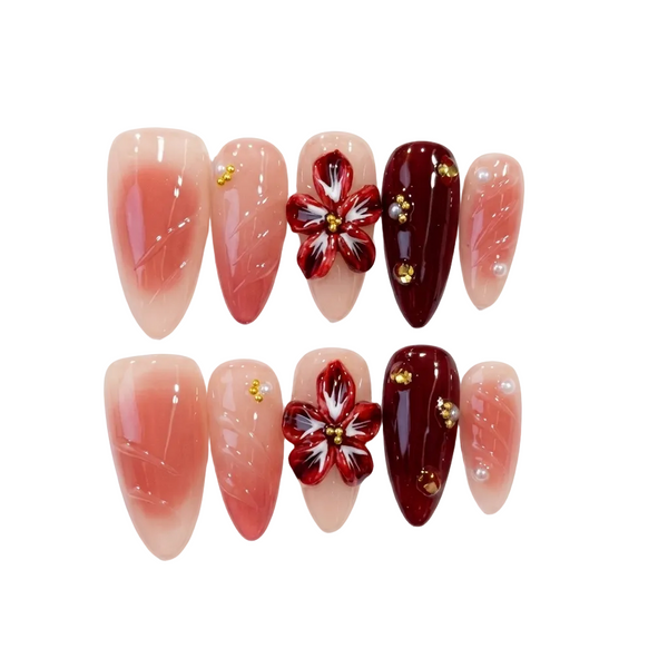 Nail art display with red floral design and gold accents on a white background