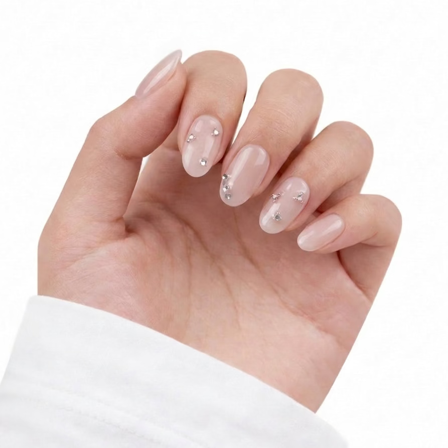 Hand with pink nail polish and small decorative elements on a white background