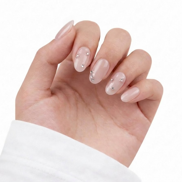 Hand with pink nail polish and small decorative elements on a white background
