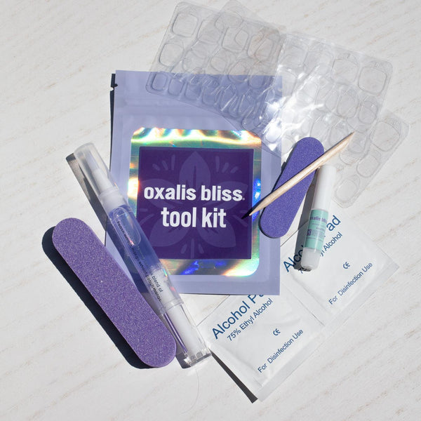 Oxalis Bliss tool kit with various items on a light gray background