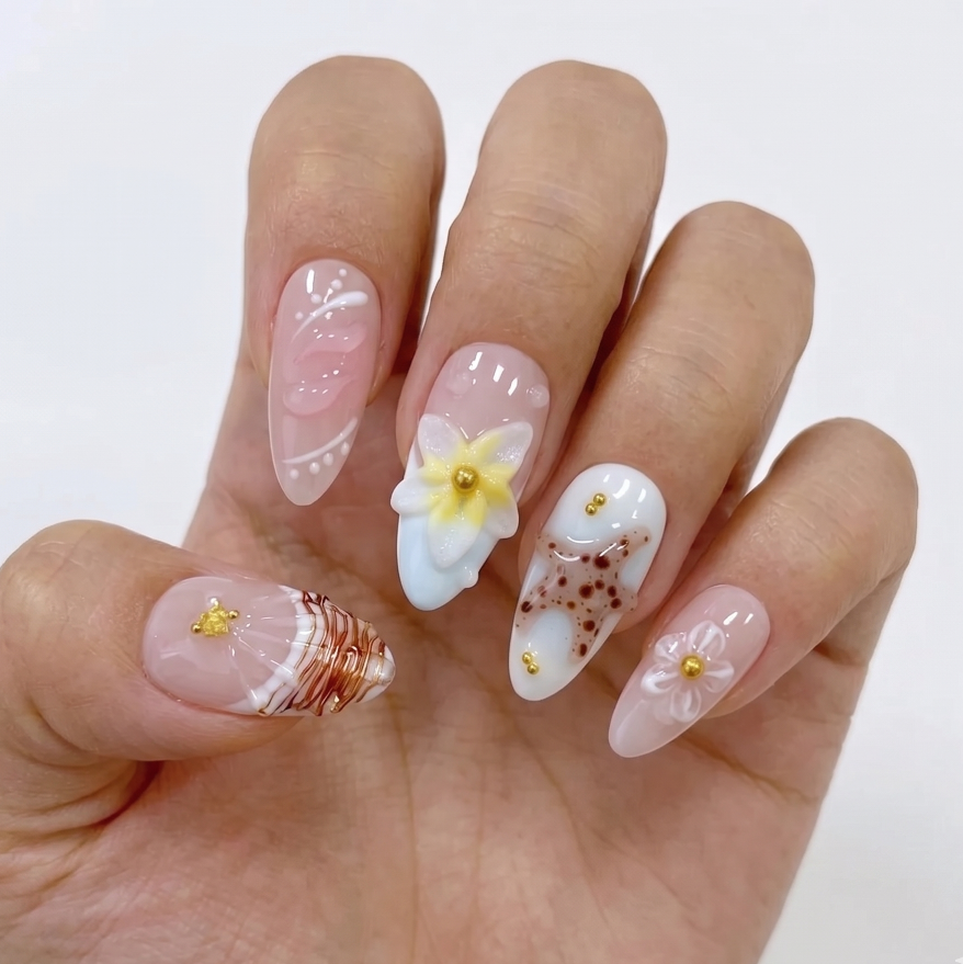 Hand with intricately designed nails featuring flowers and patterns on a white background