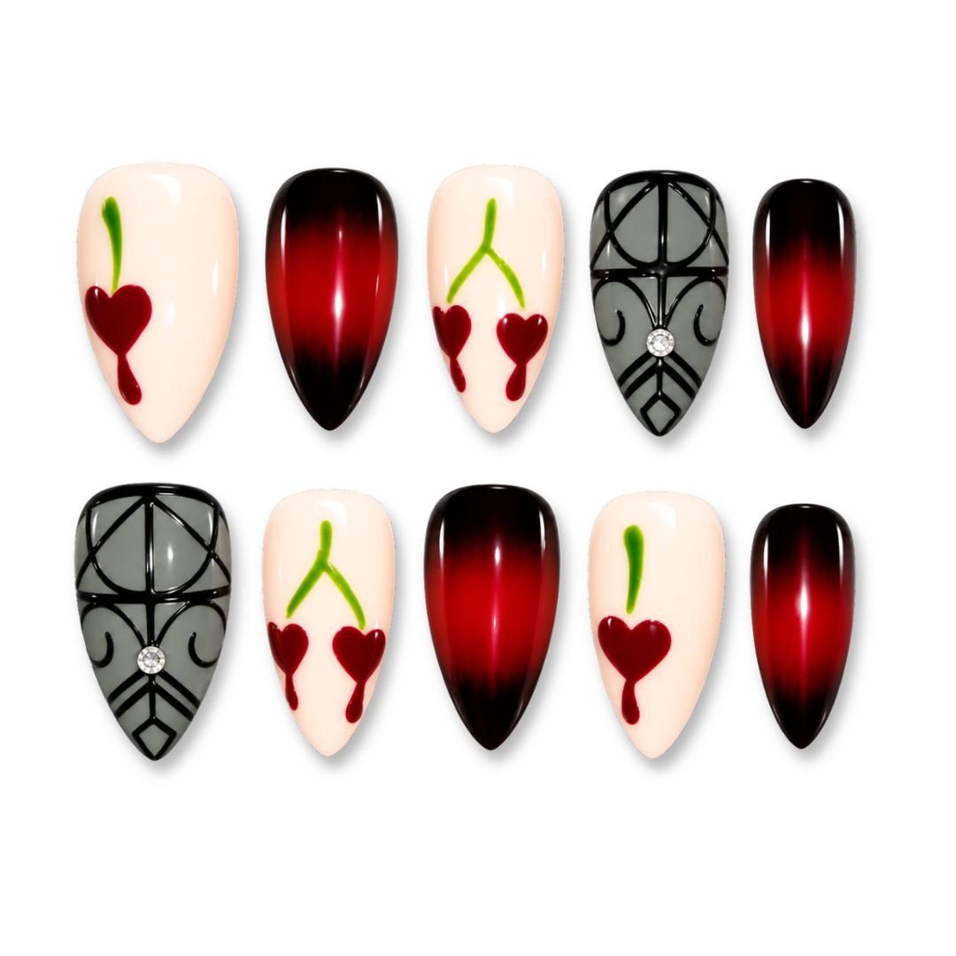 Ten artificial press-on nails arranged in two rows on a plain white background. The designs include glossy red-to-black ombre nails, cream nails with red heart and cherry motifs, and gray patterned nails with small rhinestone accents.
