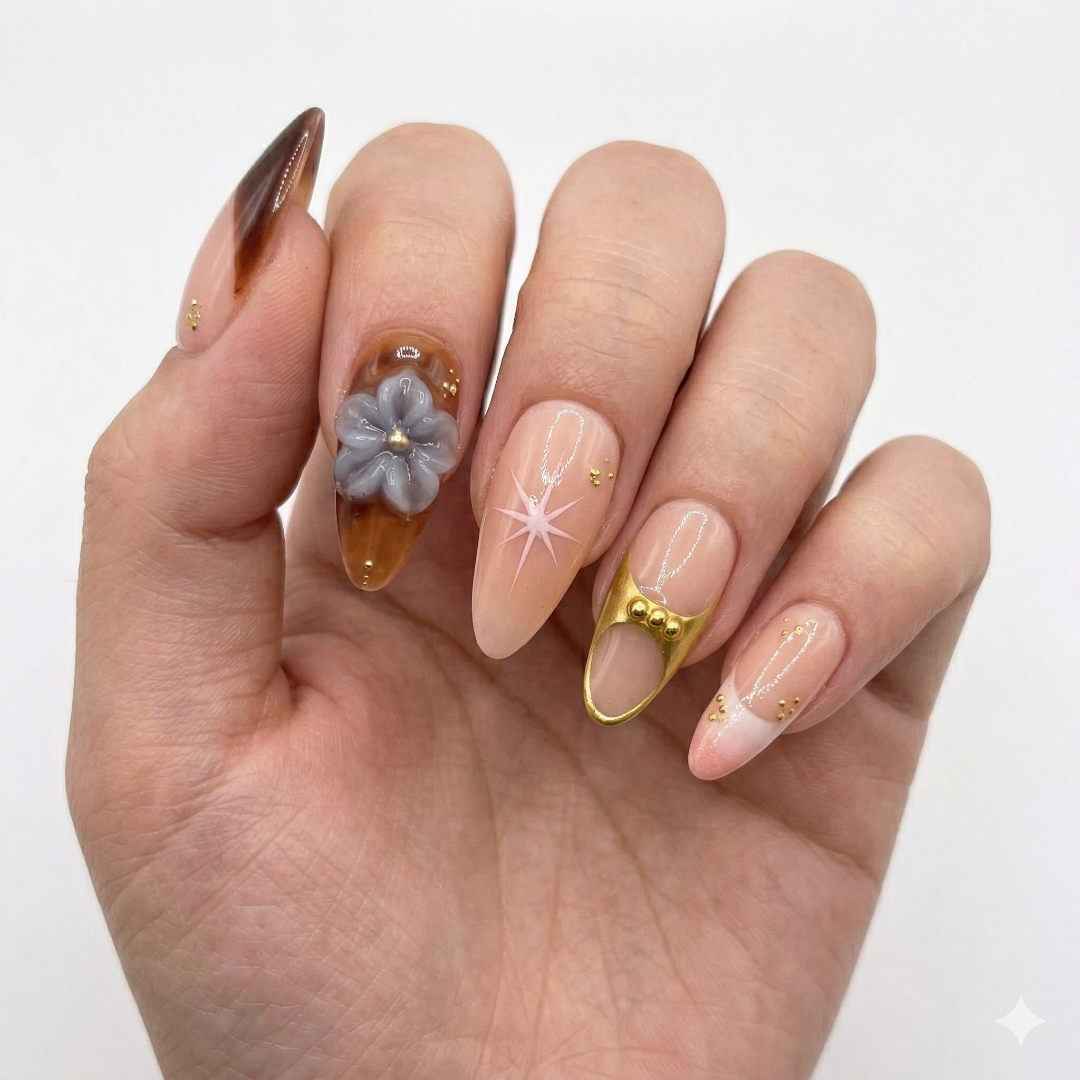 Hand with intricately designed nails featuring flowers and gold accents on a white background