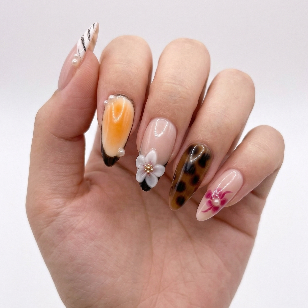 Hand with intricately designed nails on a plain background